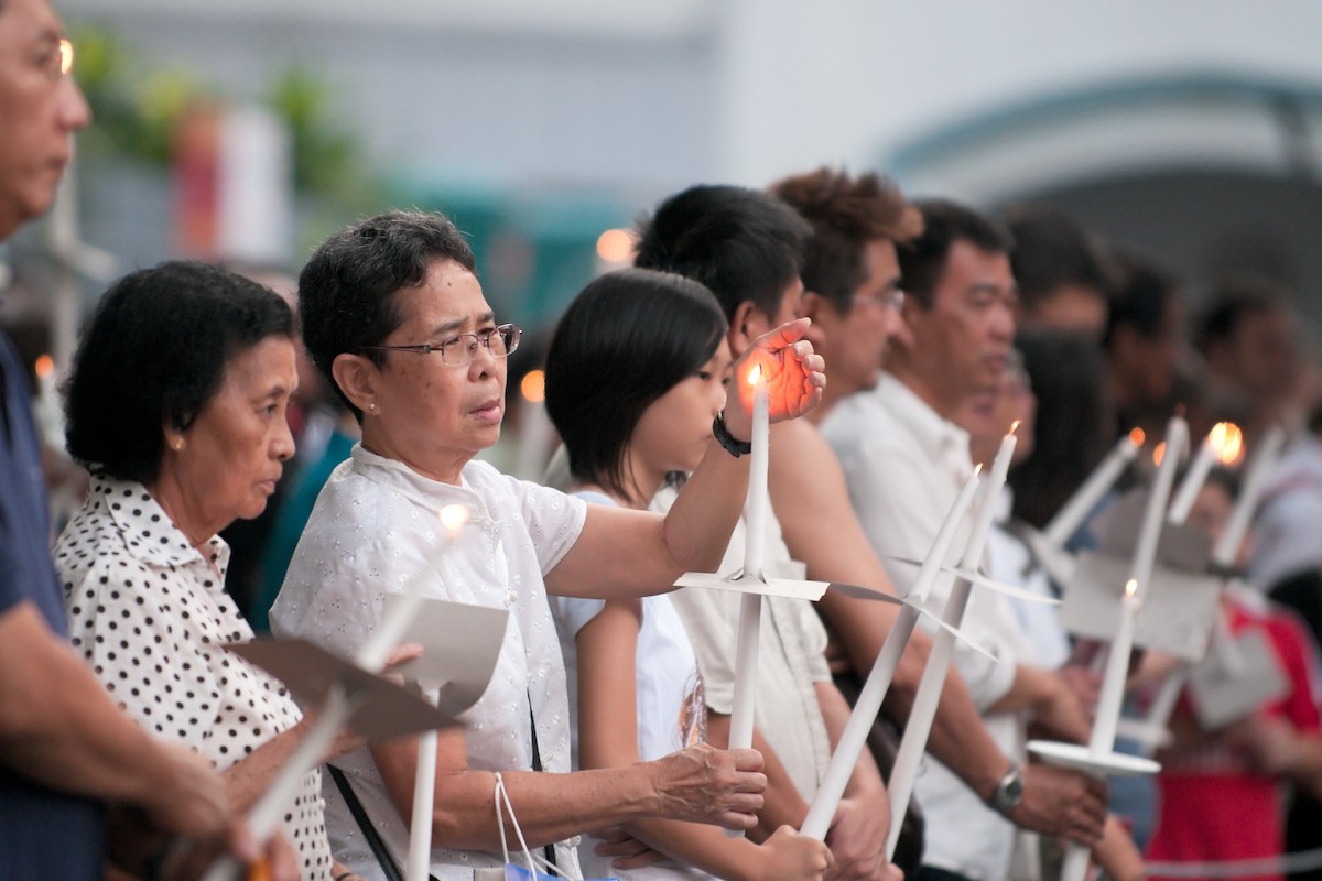 Congregants light candles at St. Joseph's Church in Singapore